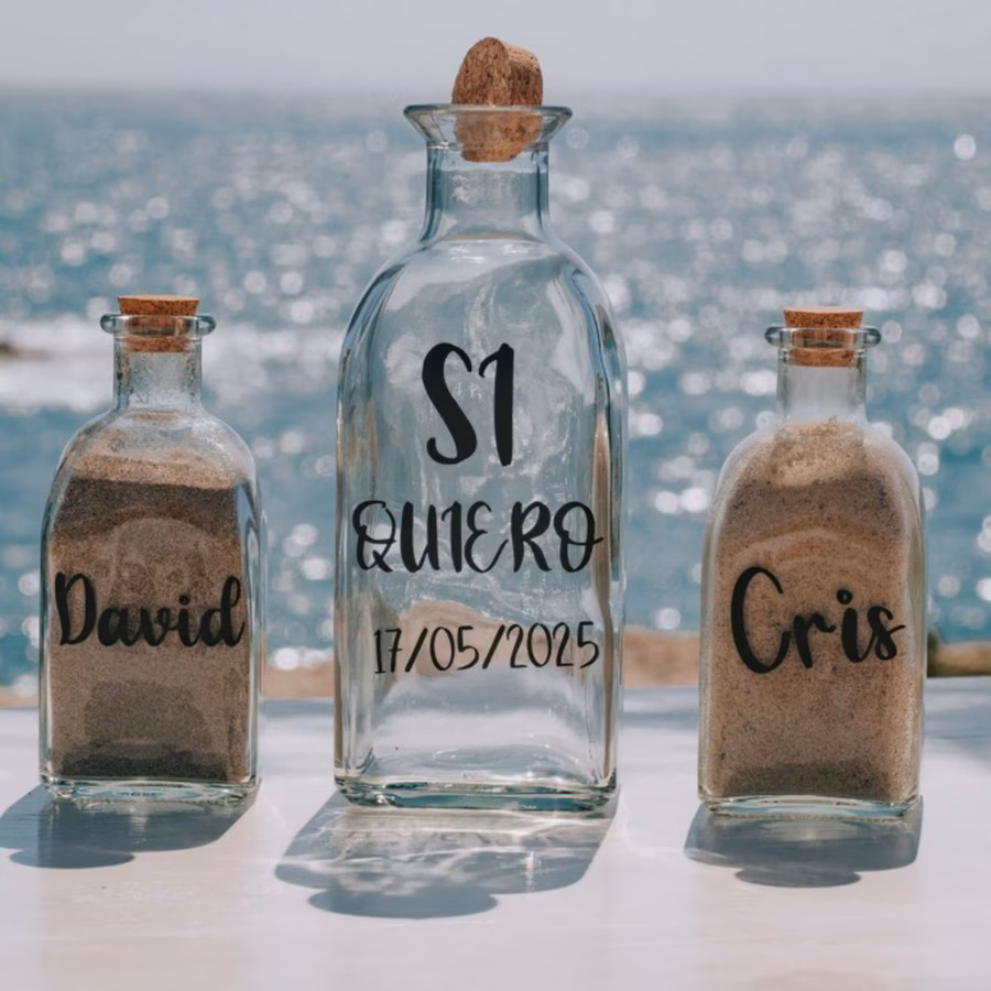 Detalle de papelería y botellas personalizadas frente al mar